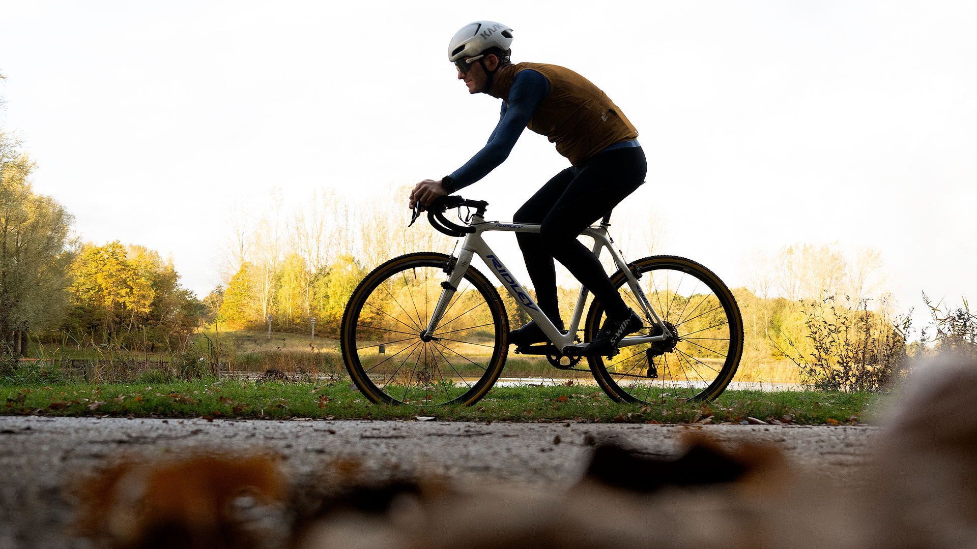 Man bikes through forested area.